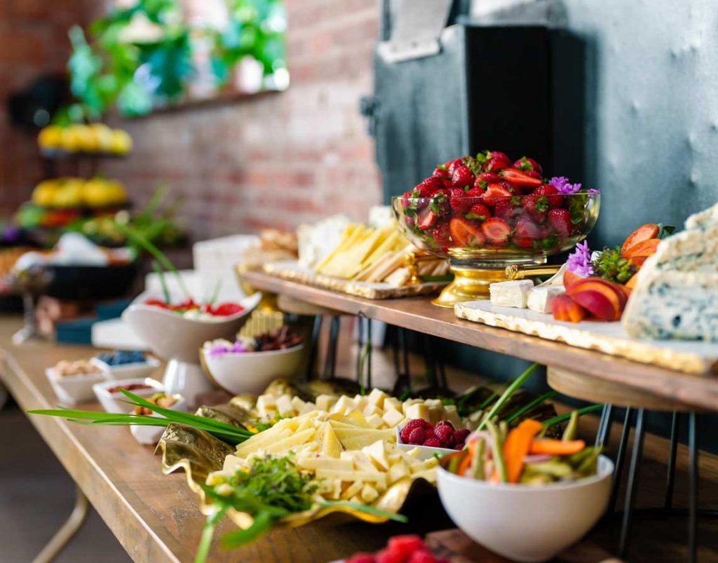 Display of a food table with two tiers of food on platters.