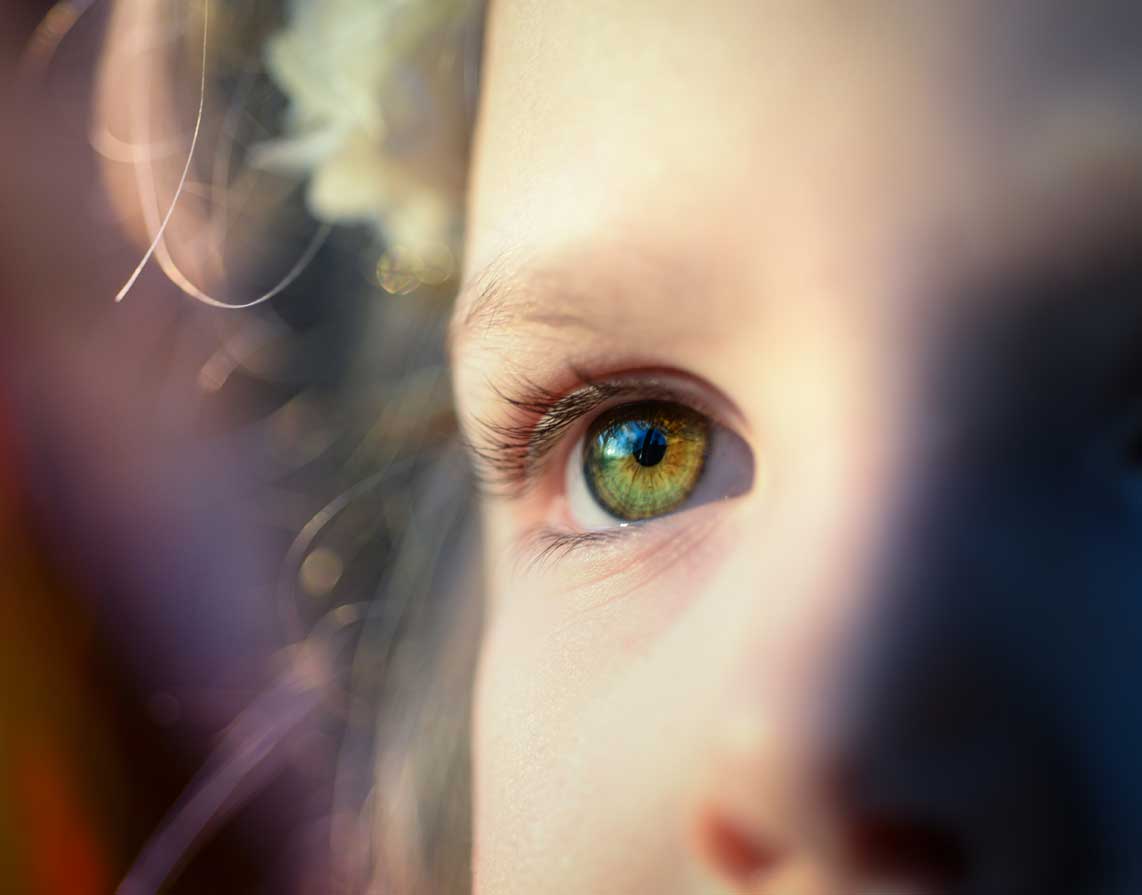 A close up of light on a child_s eye as they look into the distance