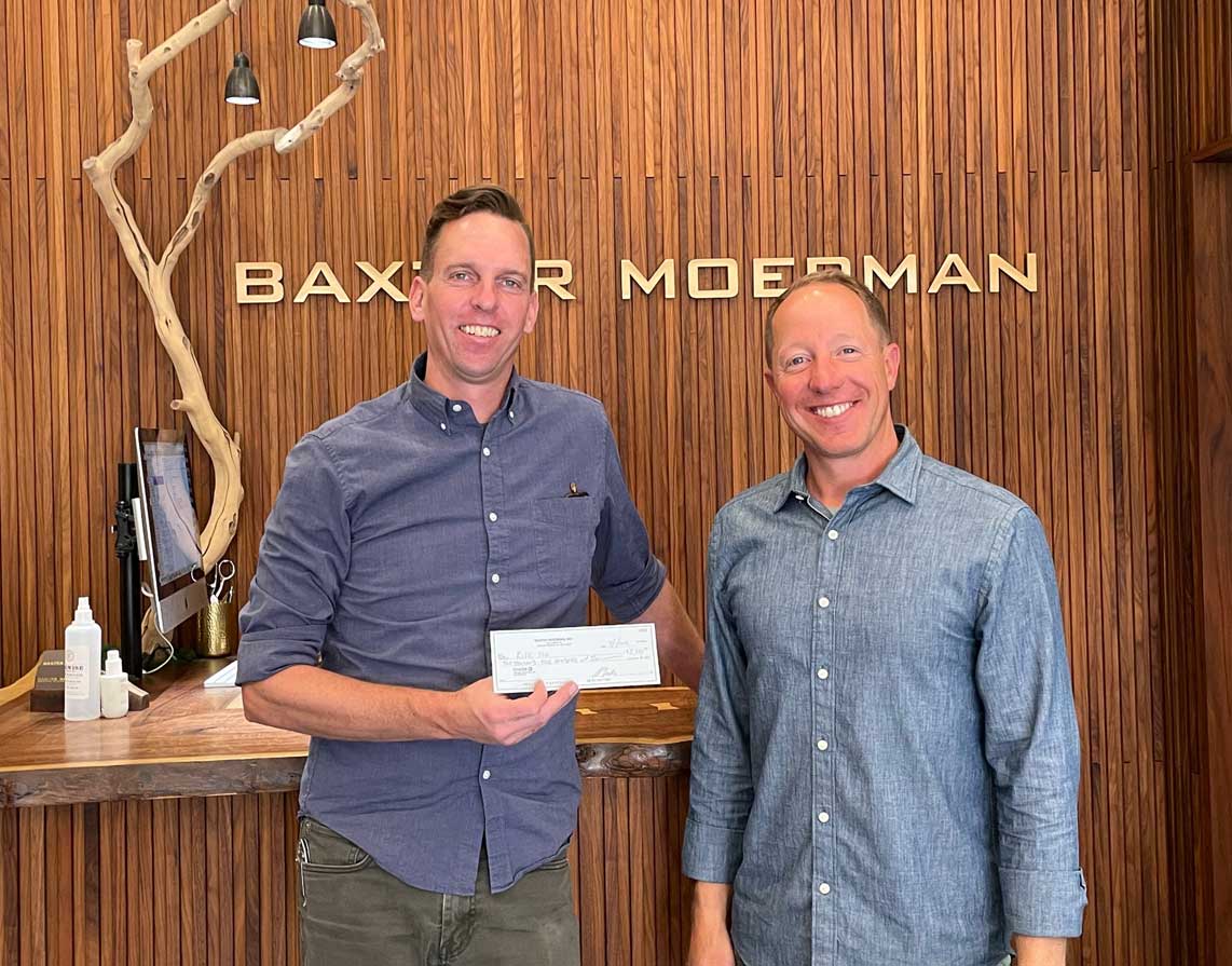 Baxter Moerman's owners holding up the donation check
